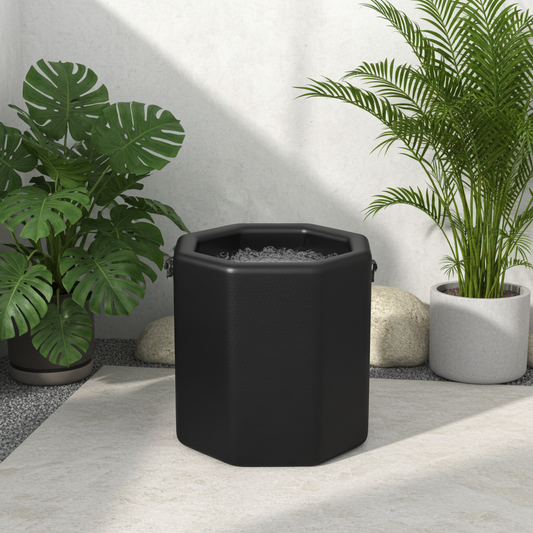 Arctic Ritual Lite+ Barrel cold plunge tub in matte black finish set in a minimalist outdoor garden with tropical plants