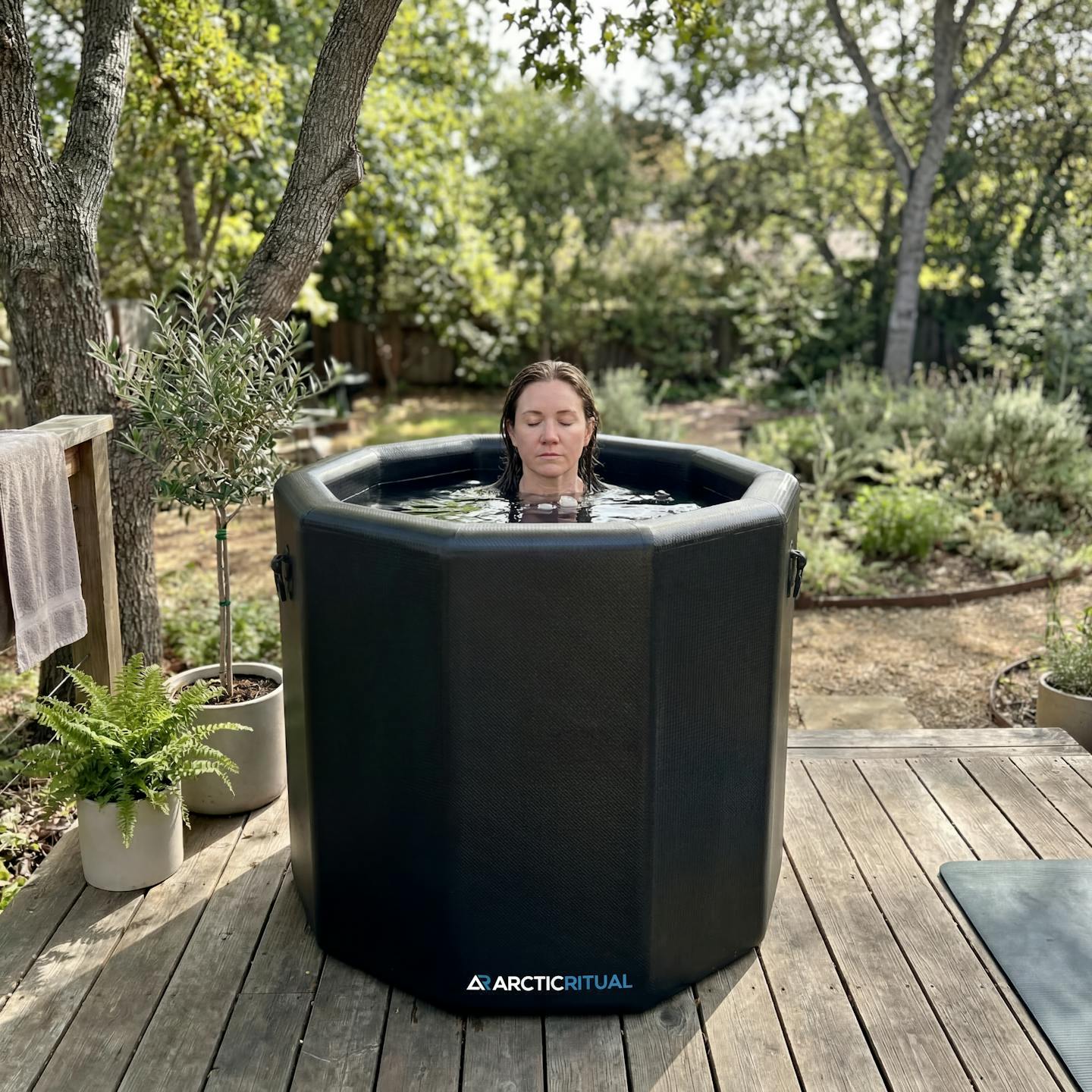 Person fully immersed in Arctic Ritual Lite+ Barrel cold plunge tub outdoors for ice bath recovery